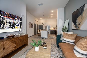 an open living room with a brown couch and a television