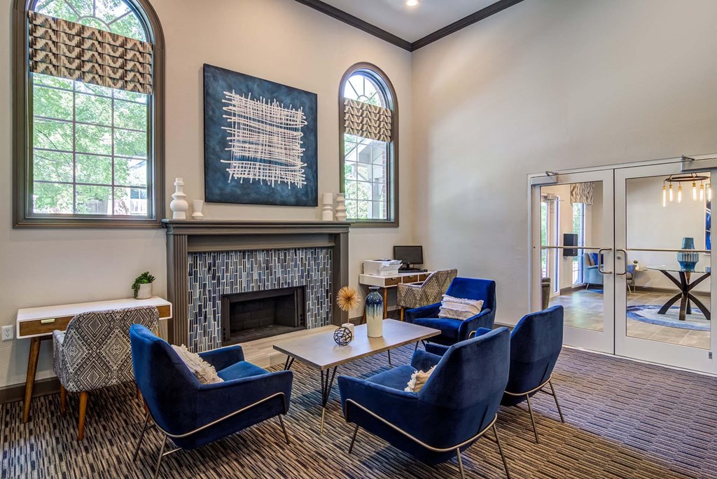 a living room with blue chairs and a fireplace