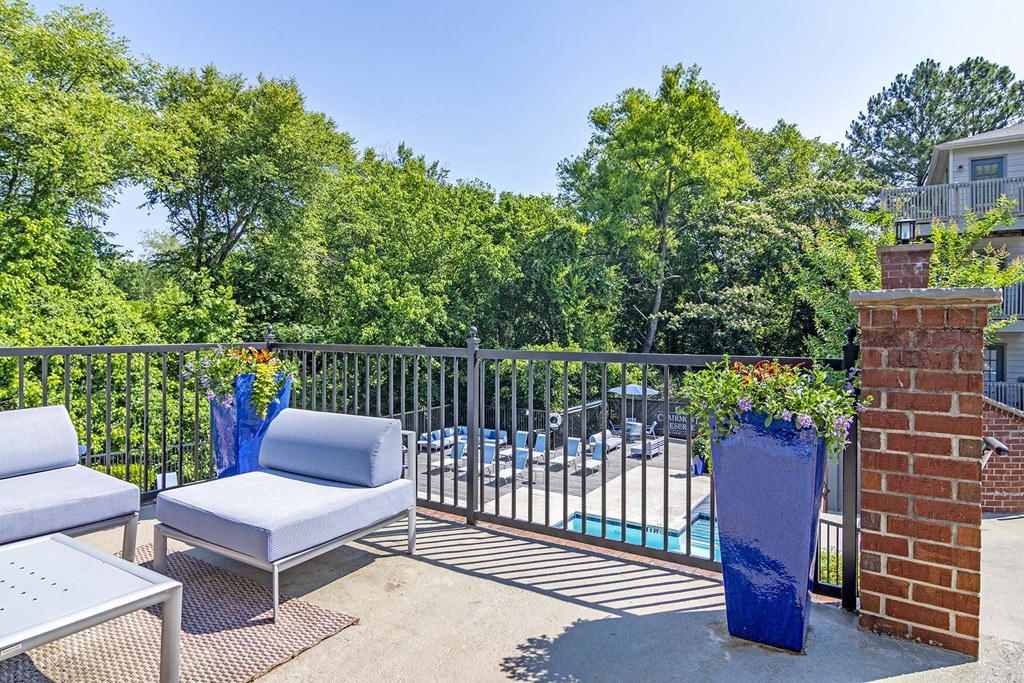 a balcony with a pool and chairs and a table