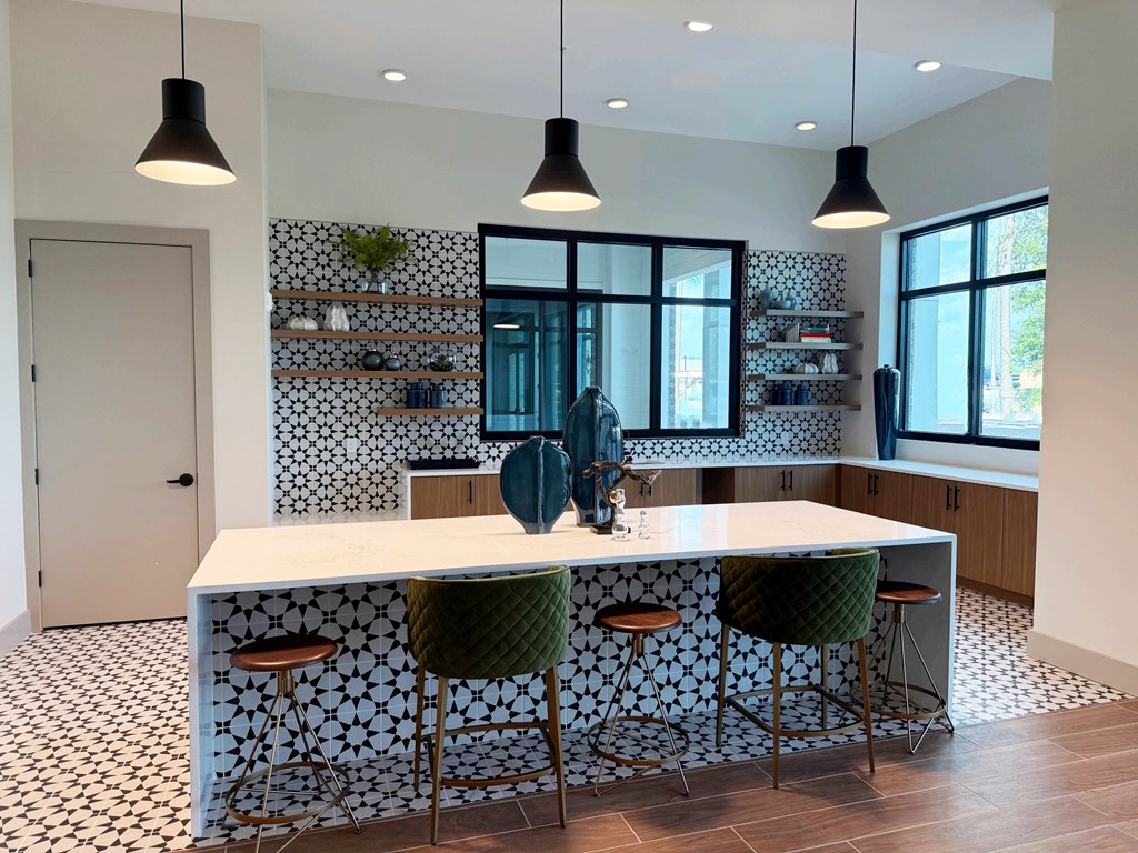A kitchen with a white countertop and bar stools.