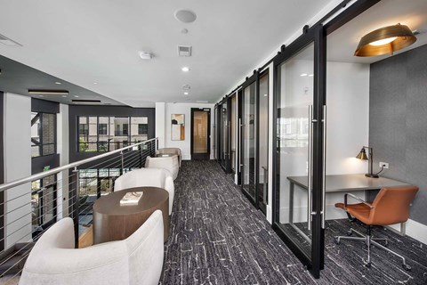 A long hallway with chairs and tables on the side.
