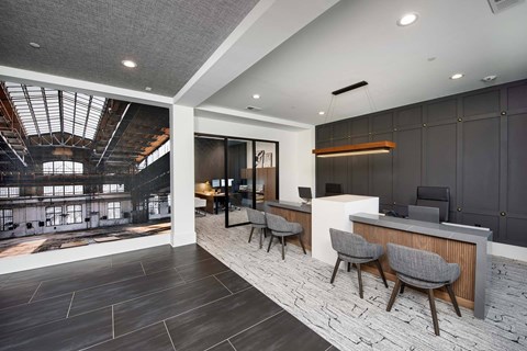 A modern office lobby with a reception desk and chairs.
