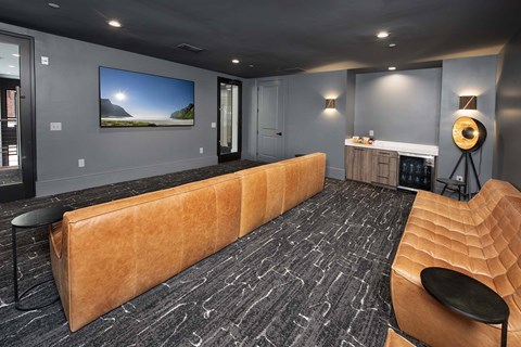 A room with a large couch and a painting on the wall.