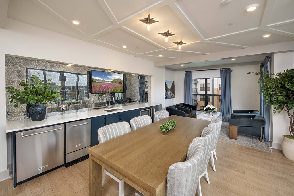 A modern kitchen with a wooden dining table and chairs.