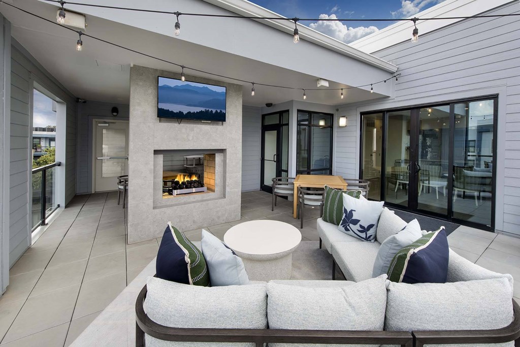 A modern outdoor living space with a fireplace and comfortable seating.