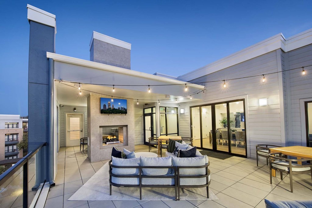 A modern outdoor living space with a couch, chairs, and a table.