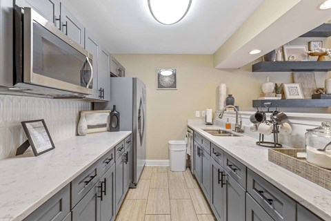 A kitchen with a white counter top and a refrigerator.