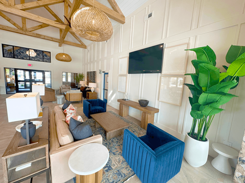 A living room with a blue couch and a television on the wall.