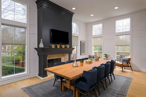a dining room with a wooden table and chairs in front of a fireplace