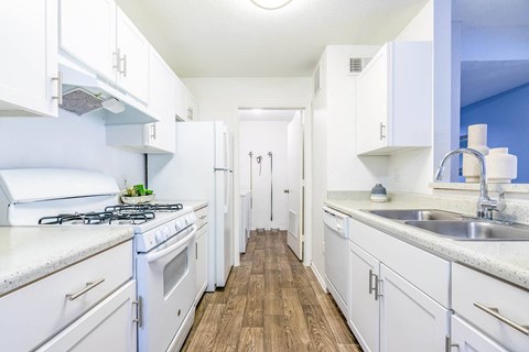 a kitchen with white cabinets and a stainless steel sink