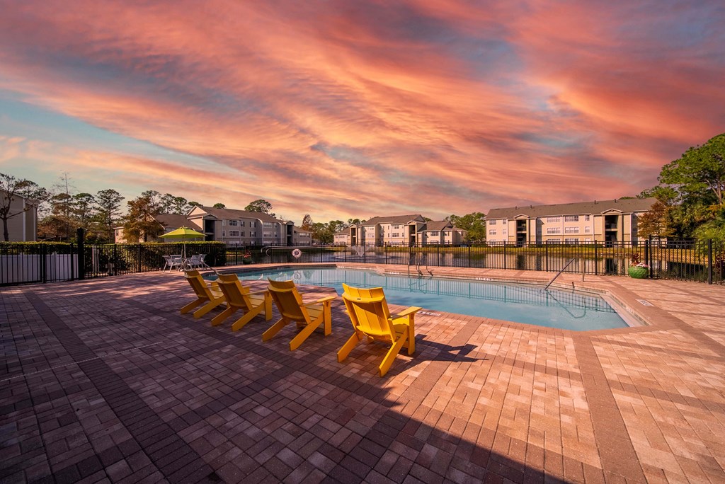 A pool surrounded by yellow sun loungers.