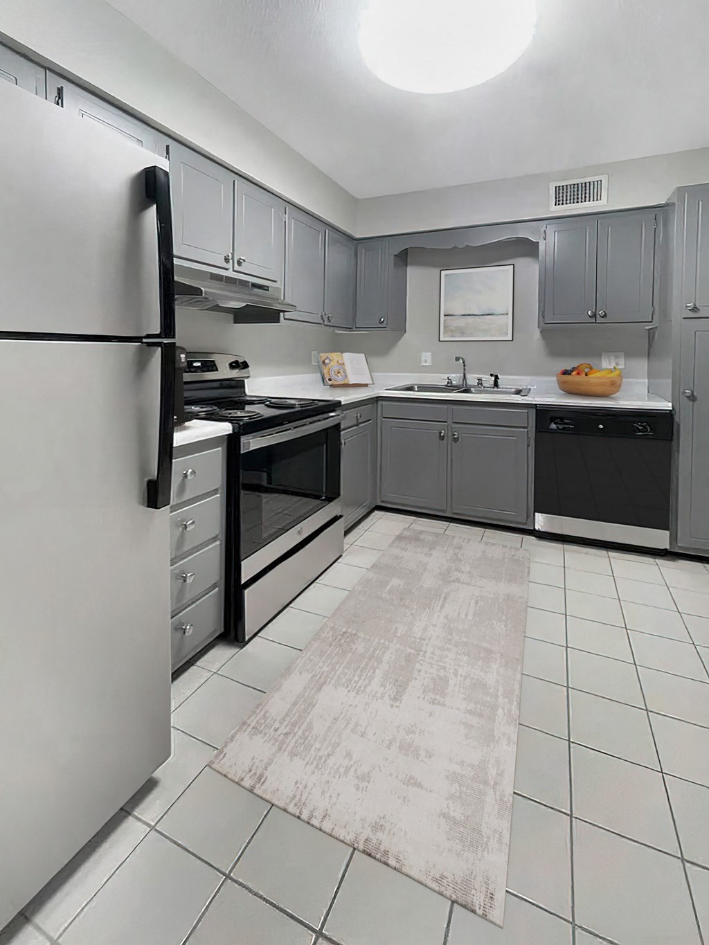 an empty kitchen with gray cabinets and black and white appliances