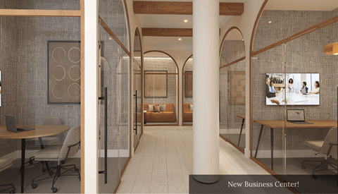A modern office space with a glass wall and a wooden floor.