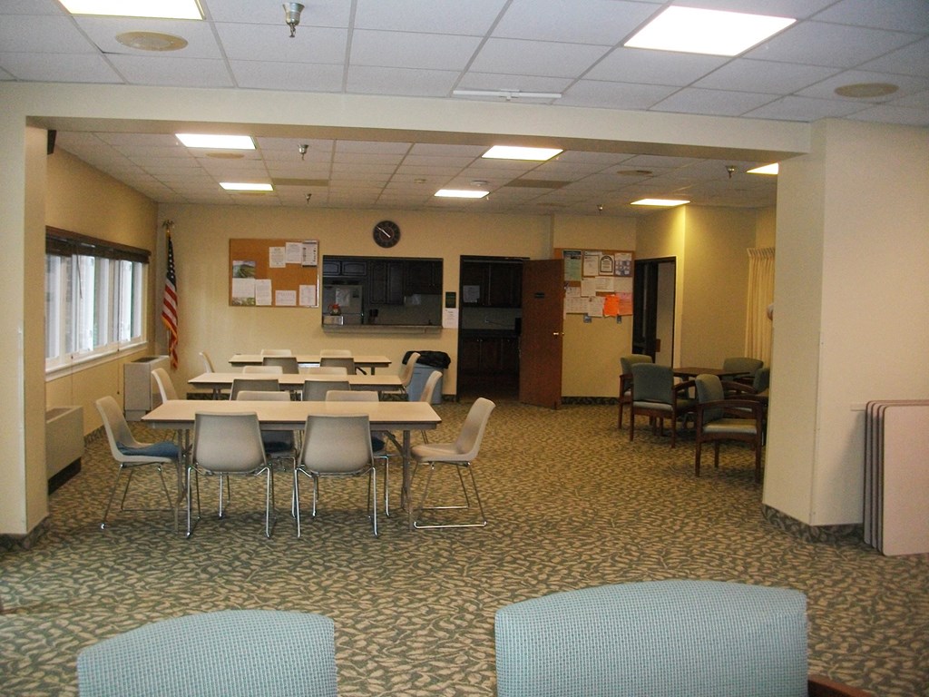 a conference room with tables and chairs and a tv