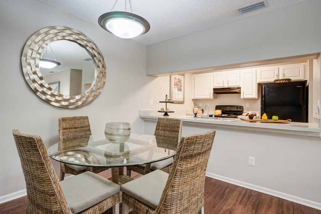 A dining room with a glass table and chairs.