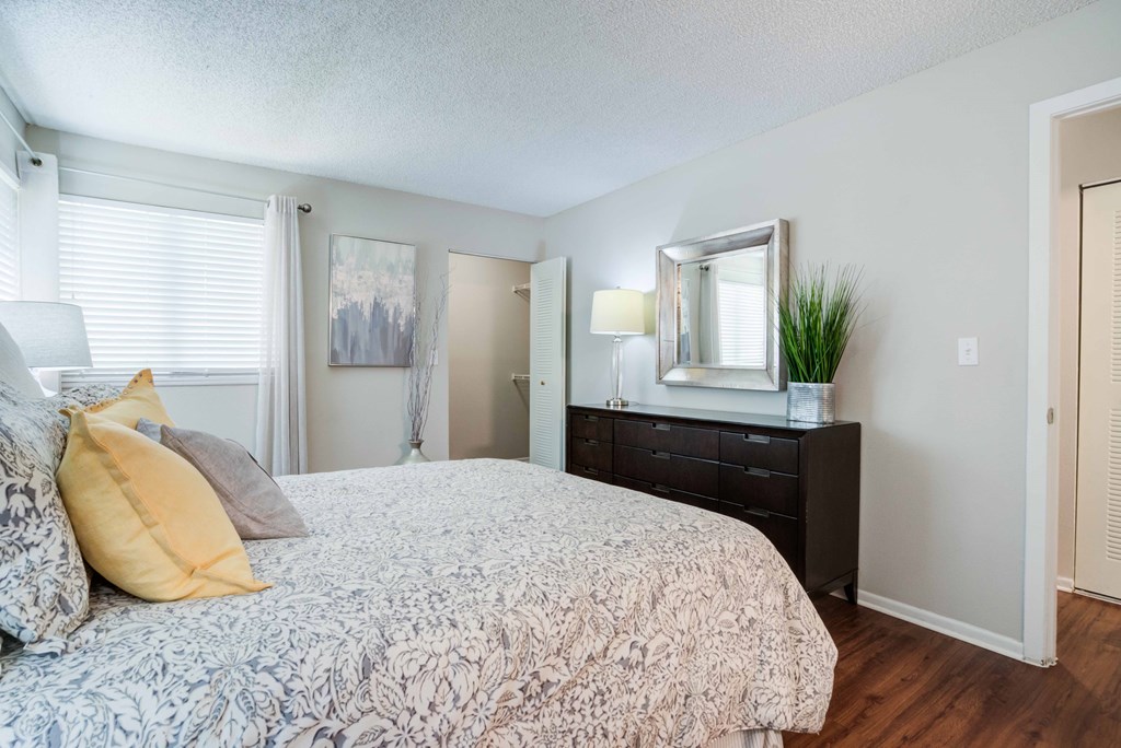 A bedroom with a bed, dresser, and mirror.