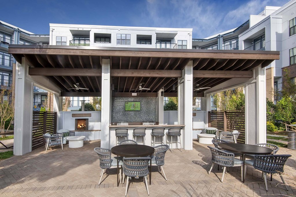 A patio with a table and chairs under a roof.