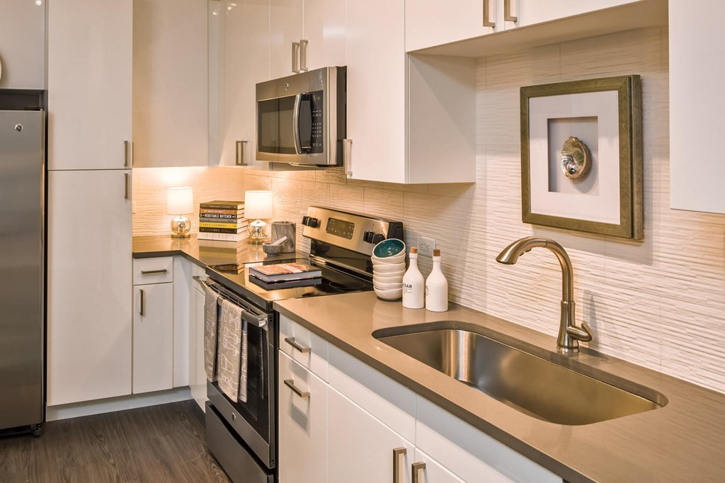 A modern kitchen with a stainless steel refrigerator and a microwave above the stove.