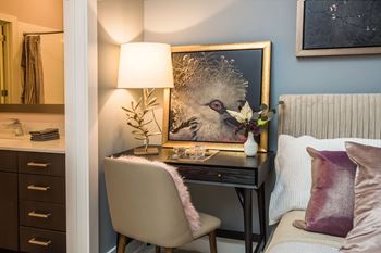 a bedroom with a desk and a chair and a painting of a bird