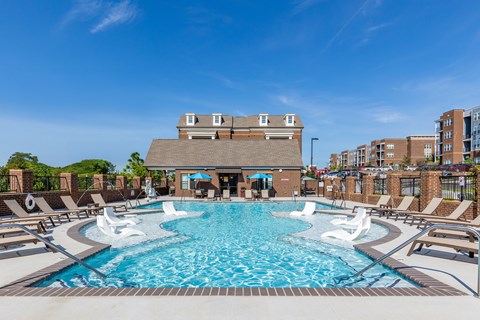 A large swimming pool with a building in the background.