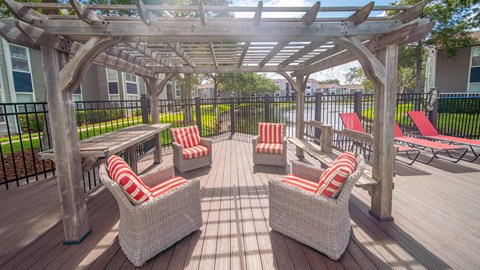 a patio with chairs and a table and a pergola
