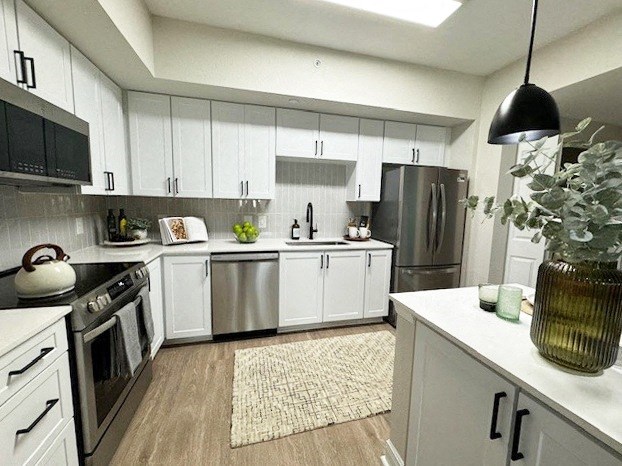 a white kitchen with stainless steel appliances and white cabinets