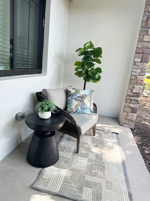 a couch with a plant and a table on a porch