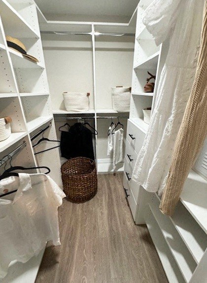 a closet with white shelves and a basket on the floor