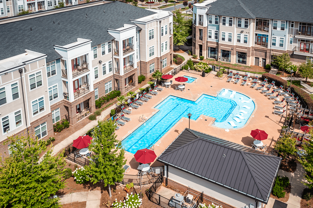 An aerial view of a pool surrounded by chairs and umbrellas.