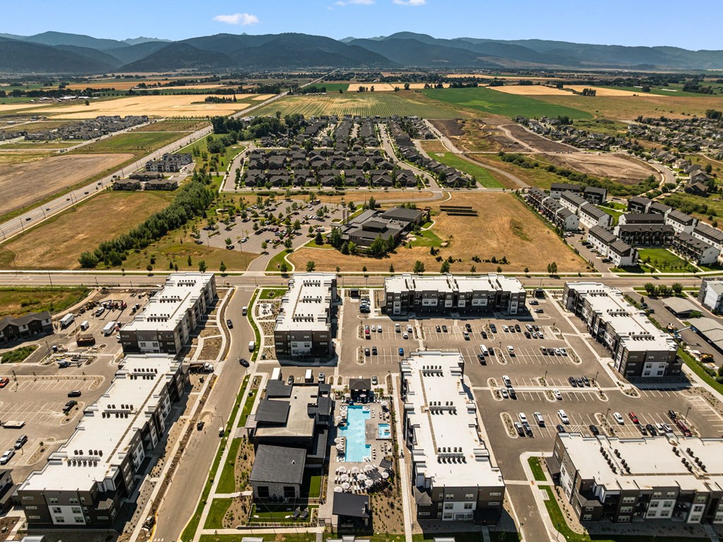 A large, well-organized residential complex with a swimming pool and surrounded by open fields.