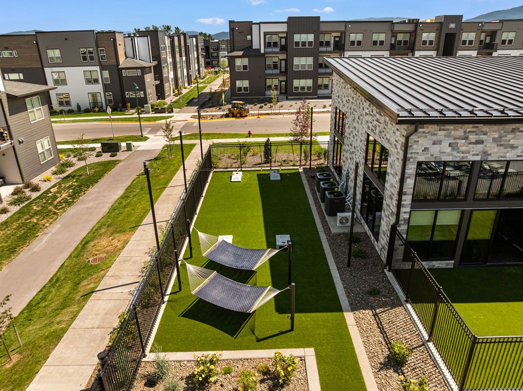 A small grassy area with a table and chairs is surrounded by a fence.
