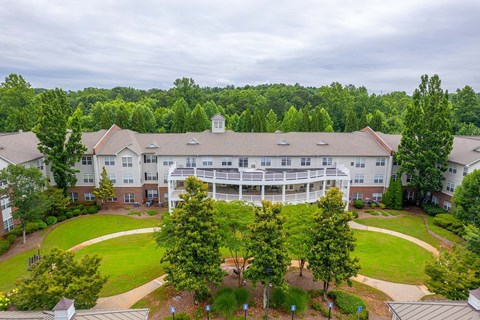 A large white building with a green lawn in front.