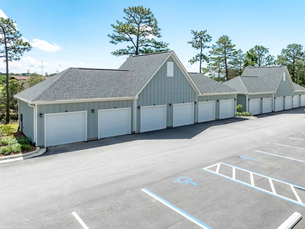 A large grey building with a parking lot in front.