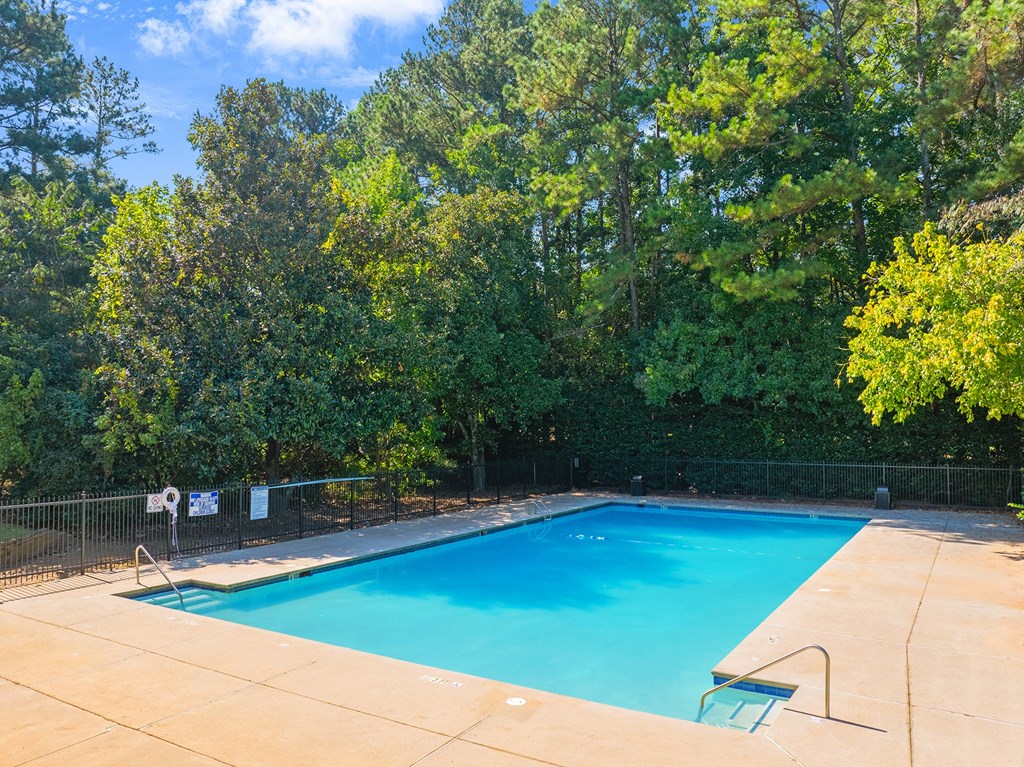 a swimming pool with trees in the background