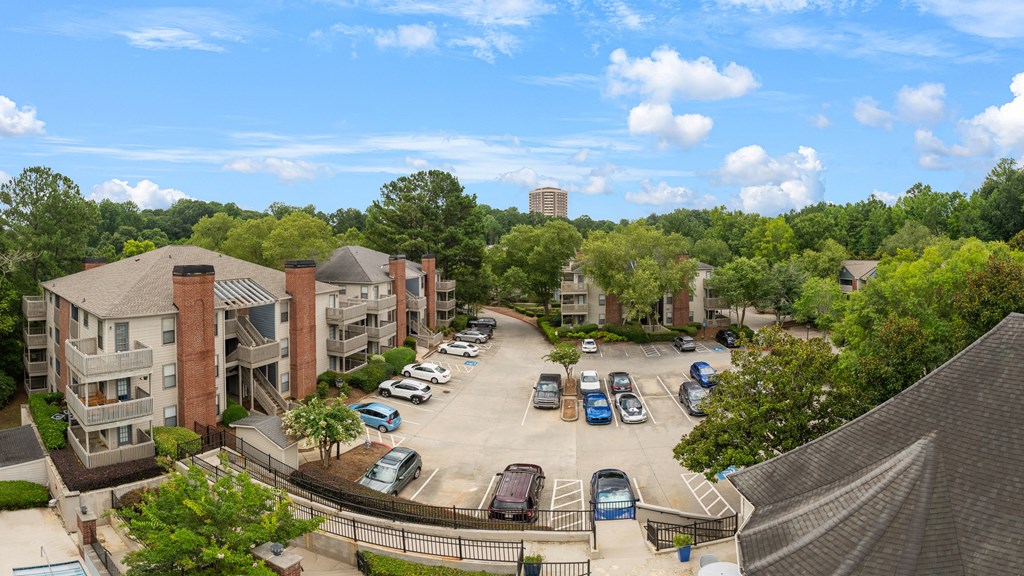 A view of a parking lot with cars and apartment buildings.