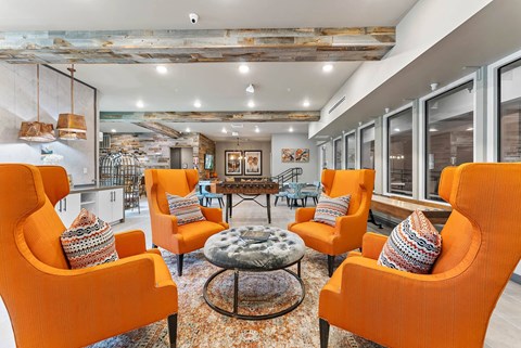 a living room with orange chairs and a table