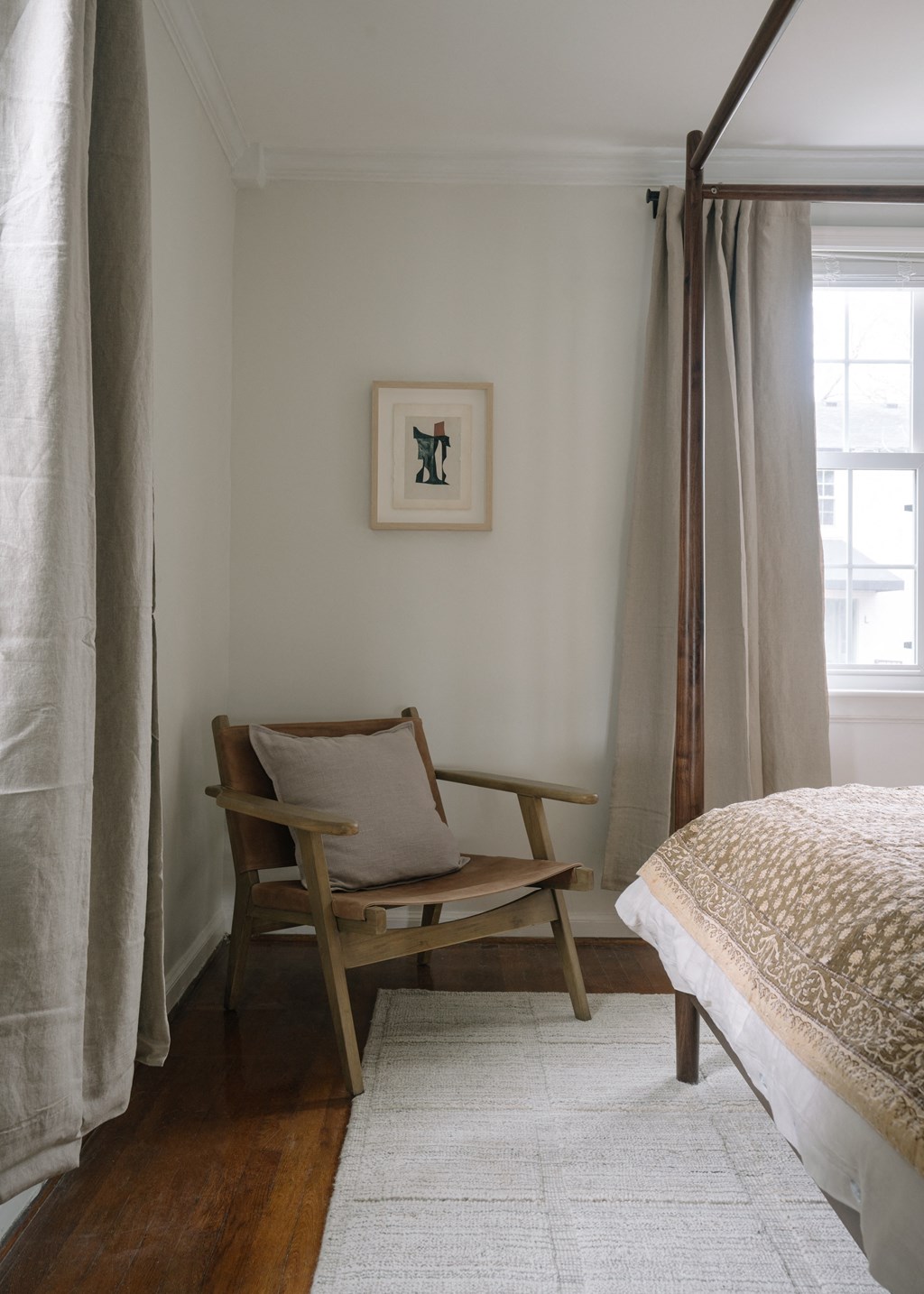 a bedroom with a bed and a chair and curtains