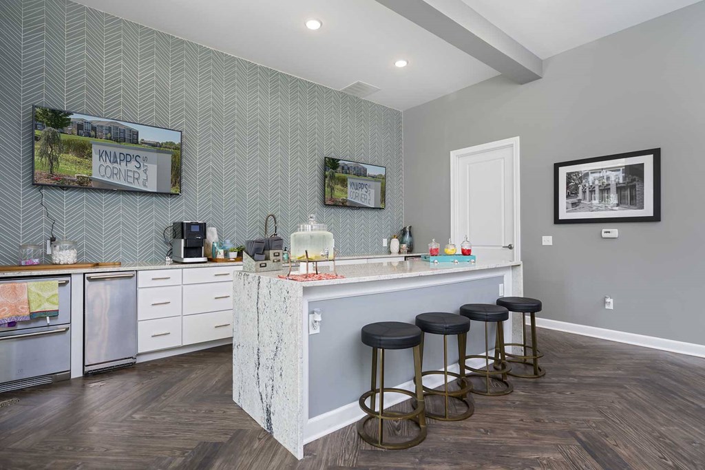 A kitchen with a bar area and stools.