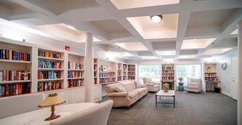 A well-lit library with bookshelves and comfortable seating.