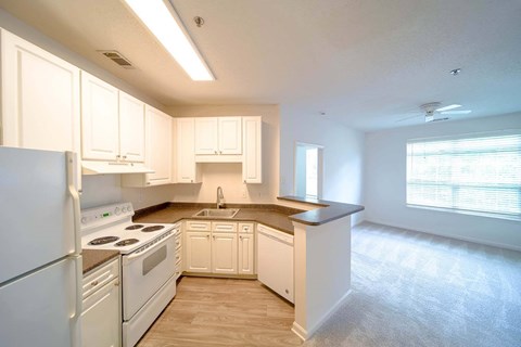 A kitchen with white cabinets and appliances.