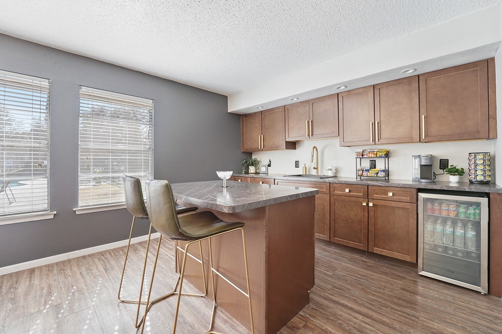 A kitchen with a table and chairs in front of a refrigerator.