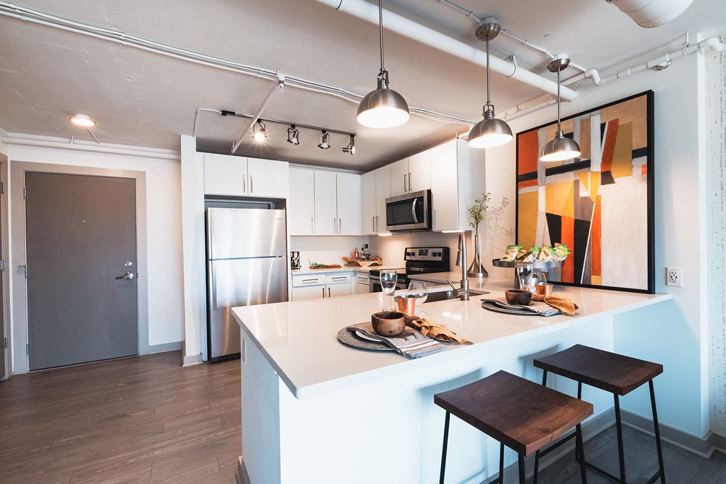 a kitchen with a white counter top and a stainless steel refrigerator