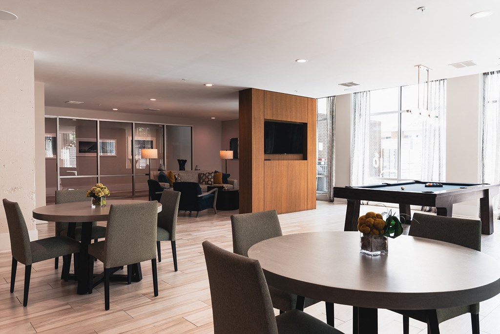a living room with tables and chairs and a pool table