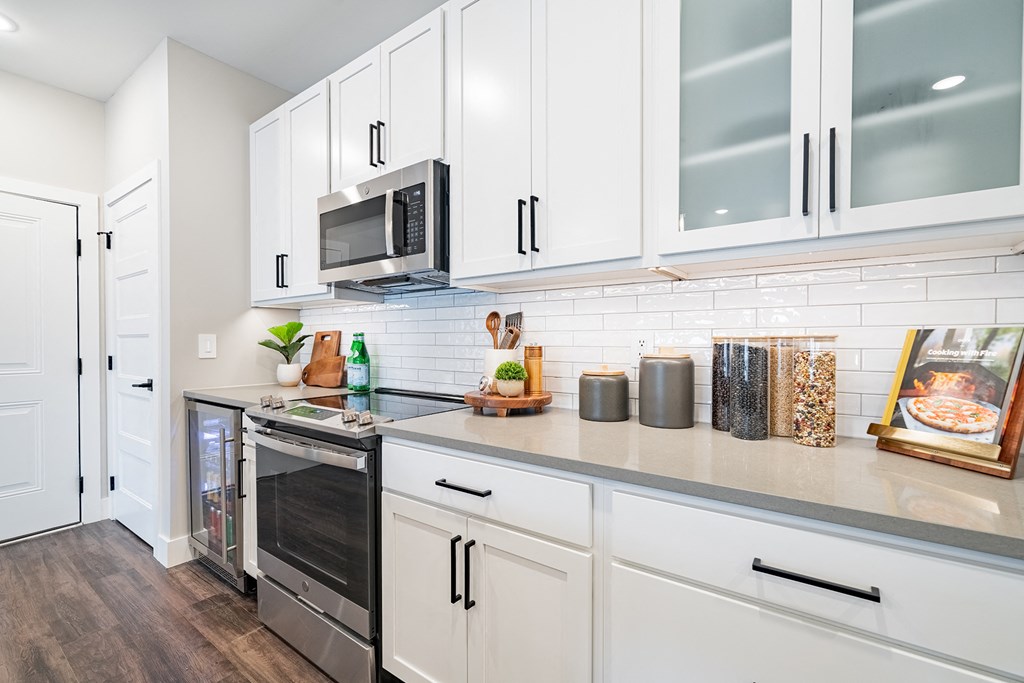 a kitchen with white cabinets and stainless steel appliances and a microwave