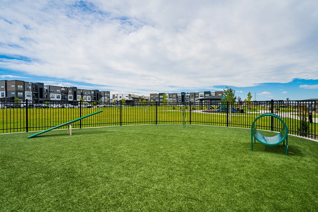 a playground with a swing set on a lush green field