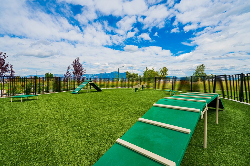a playground with benches on the grass and a fence
