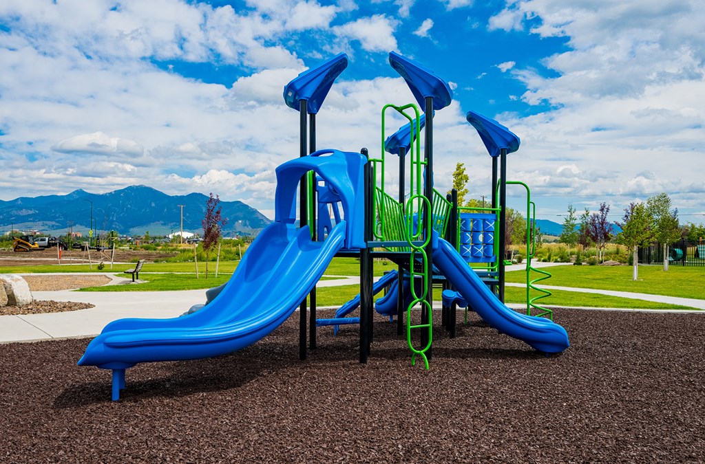 a playground with a blue slide in a park