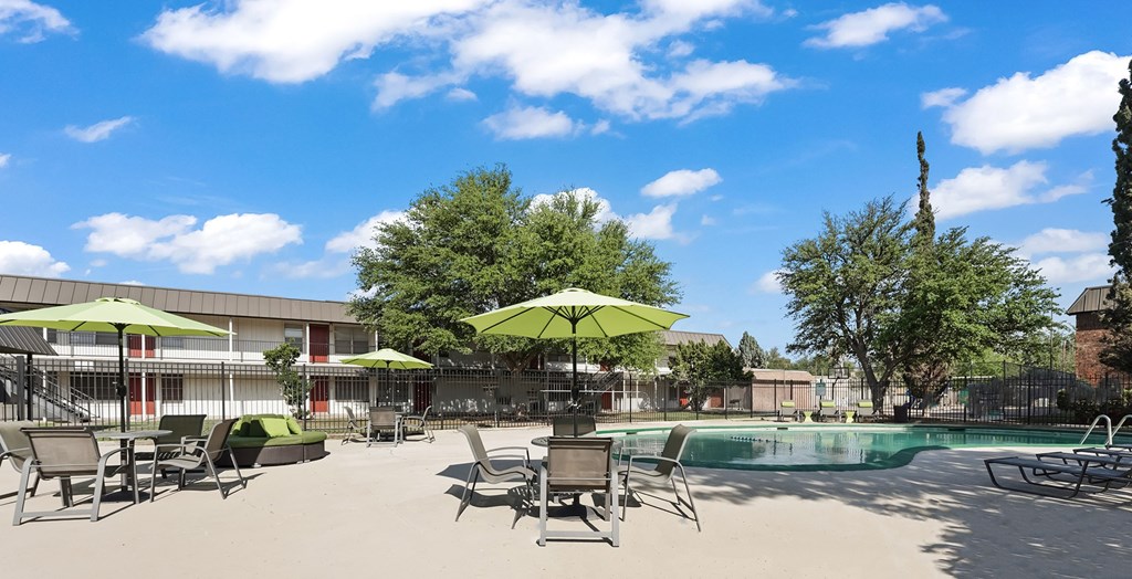A pool area with sun loungers and umbrellas.