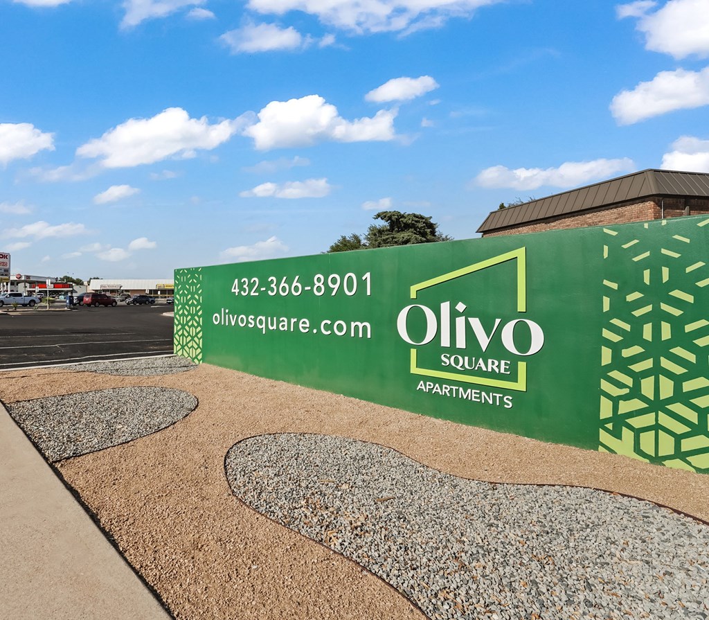 A green and white sign for Olivo Square Apartments with a phone number and website listed.