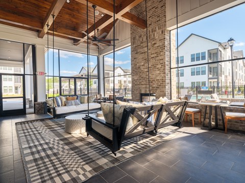A modern living room with a black and white checkered rug and a wooden ceiling.
